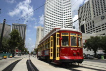 Street Car travelling along tracks passing highrise buildings