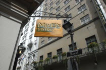 French Quarter. Sign hanging outside Mr B s Bistro on Royal Street with highrise buildings behind