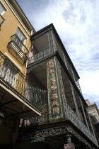 French Quarter. Angled view looking up at ornate ironwork balcony of a restaurant