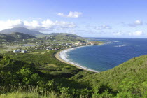 View over green hills and coastline with sandy bay