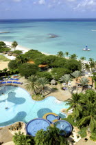 View over beach side hotel pool with clear blue sea beyond