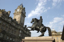 Angled view looking up at the Balmoral Hotel clocktower with equestrian statue in the foreground