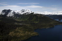 Aerial view over coastal landscape and snow capped mountain peaks