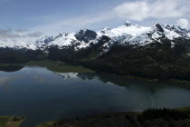 View over waters toward snow capped mountain peaks