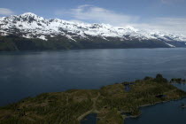 View over waters toward snow capped mountain peaks