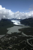 Aerial view over town and waters leading toward snow covered valley and mountain peaks