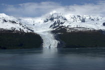 View over calm waters of the bay toward snow capped mountain range