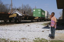 Child watching passing freight train.