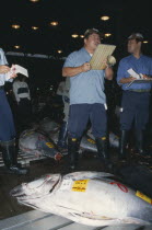 Tsukiji Market.  Tuna fish for sale and auctioneer.