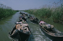 Sturgeon fishermen in shallow wooden boats linked to each other by rope returning to Black Sea.