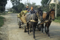 Men and child in horse drawn wooden cart.