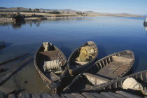 Wooden fishing boats moored beside wooden jetty.