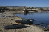 Fishing boats pulled up on lake shore.