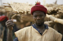 Miner holding up phial of gold dust.West Africa