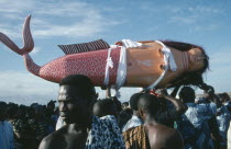 Coffin made and painted to resemble a mermaid for Ga tribal priestess of sea god carried by funeral guests.