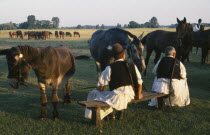 Dismounted cossack horseman with pair of horses and donkey.