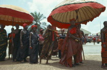 Ashanti tribe with umbrellas denoting office attending funeral.  Seen as a celebration a funeral typically lasts several days and is attended by the whole village. Asante  Akan people