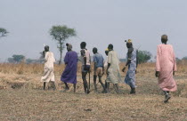 Dinka bridegroom in purple with members of his clan who will negotiate a bride price in the form of a dowry of cattle.