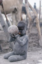 Dinka child drinking milk from gourd.