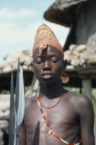 Portrait of Dinka boy holding spears.