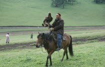 Kazakh falconer on horeseback with eagle used for hunting