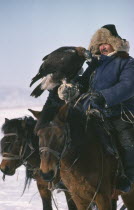 Kazakh man on horseback with eagle used for hunting