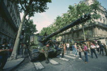 Bastille Day celebrations on July 14th.  Crowds looking at tanks in city street.