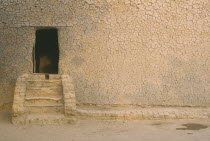 Mud house  exterior detail with steps leading to doorway