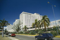 Downtown.  Oceana Hotel overlooking road lined by palm trees and parked cars.