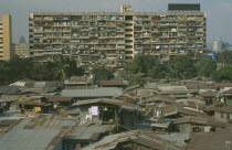 View over inner city corragated slum housing towards highrise building.