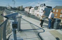 Old Portsmouth. People standing on path leading to the Square Tower with a Talking Telescope in the foreground