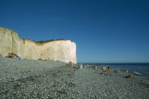 Occupied peeble beach and section of cliff face