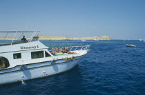 Divers prepare to dive off boat.