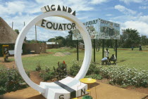 Uganda, Equator, North and South sign. Corruption kills sign in the background.