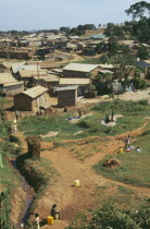 Uganda, Kampala, Looking across the poorer town outskirts. Women collecting water in foreground.