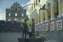 St Pauls Ruins with sculpture of a man and woman holding a flower standing in a red ring.