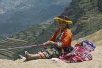 Quechuan Indian woman weaving  inca terracing behind. Sacred ValleyCuzco Pisaq Cuzco Pisaq