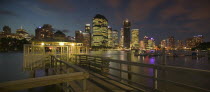 View from a pier  of the CBD across the Brisbane River at dusk with boats on one side.Tourism  Travel  Holidays  State Capital  Panorama  Skyline  Skyscrapers  Night Time exposure  Central Business D...