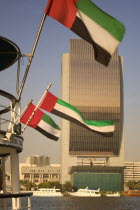 The National Bank with Emirates national flags flying from the stern of a boat in the foreground.Travel  Tourism  Dubayy  United Arab Emirates