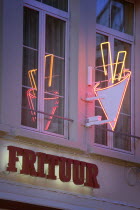 Detail of a neon chip shop sign with reflection in window.Holidays  Tourism  Travel  Icon  Cuisine  Frites  Chips  Frituur