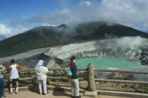 Volcan Poas National Park. View from the observation platform with tourists looking over crater.