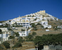 Ermoupolis. The Catholic quater of Ano Syros and church of Ag. Yiorgios. Houses covering mountain side with trees and a wall in the foreground.