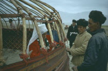 Nomadic Kirghiz men and women building frame for traditional ger.Kyrgyz Yurt