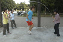 Harajuku. Yoyogi Park. 24 year old student Kusan Osaki  jumps rope with friends on Saturday afternoon