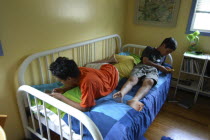 11 year old Dylan Demanski  and visiting friend 12 year old Satoshi Ui of Japan play gameboys on Dylans bed  both boys are adopted  Dylan of Tibetan parentage