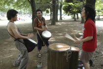 Harajuku. Yoyogi Park. Hiroaki Komura  and his brother Kenichi  with their friend Tomokazu Nagashima  playing African drums on a Saturday afternoon