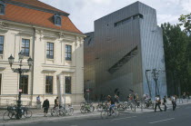 Visitors at entrance to the Jewish Museum designed by Polish architect Daniel Libeskind situated beside traditional building with bicycles chained up outside.