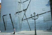 Visitors walking past the zinc clad facade of the Jewish Museum designed by Polish architect Daniel Libeskind in 1998 and opened in 2001.