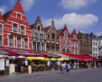 Line of cafes and restaurants with colourful awnings in Bruges market place Flemish Region