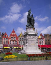 Statue of Jan Breydel and Pieter de Coninck in the market place. Row of cafes and restaurants behind.